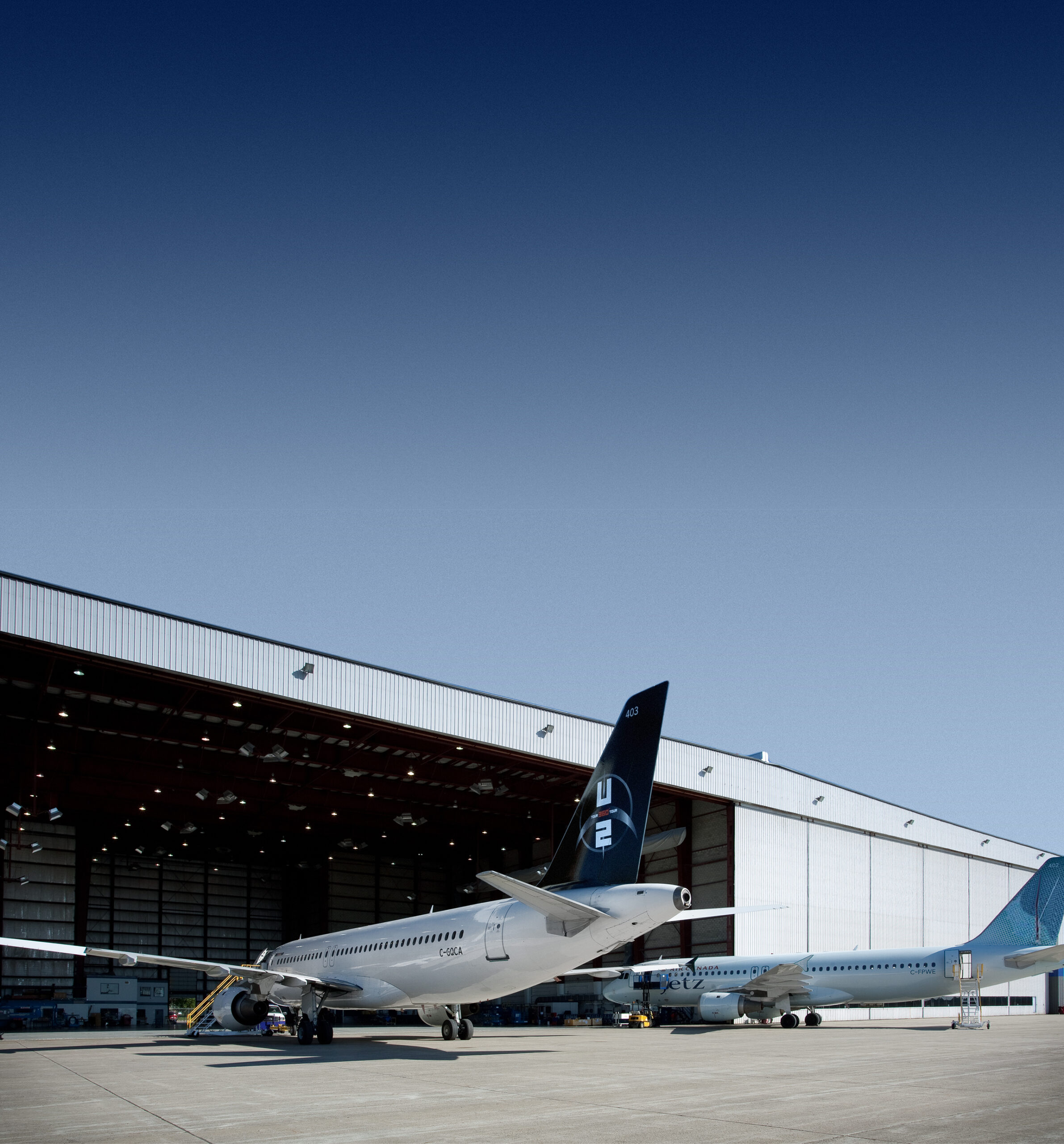 Avions devant un hangar de maintenance